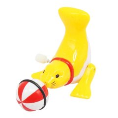 Заводна іграшка "Тюлень з мʼячиком", жовта купити в Україні